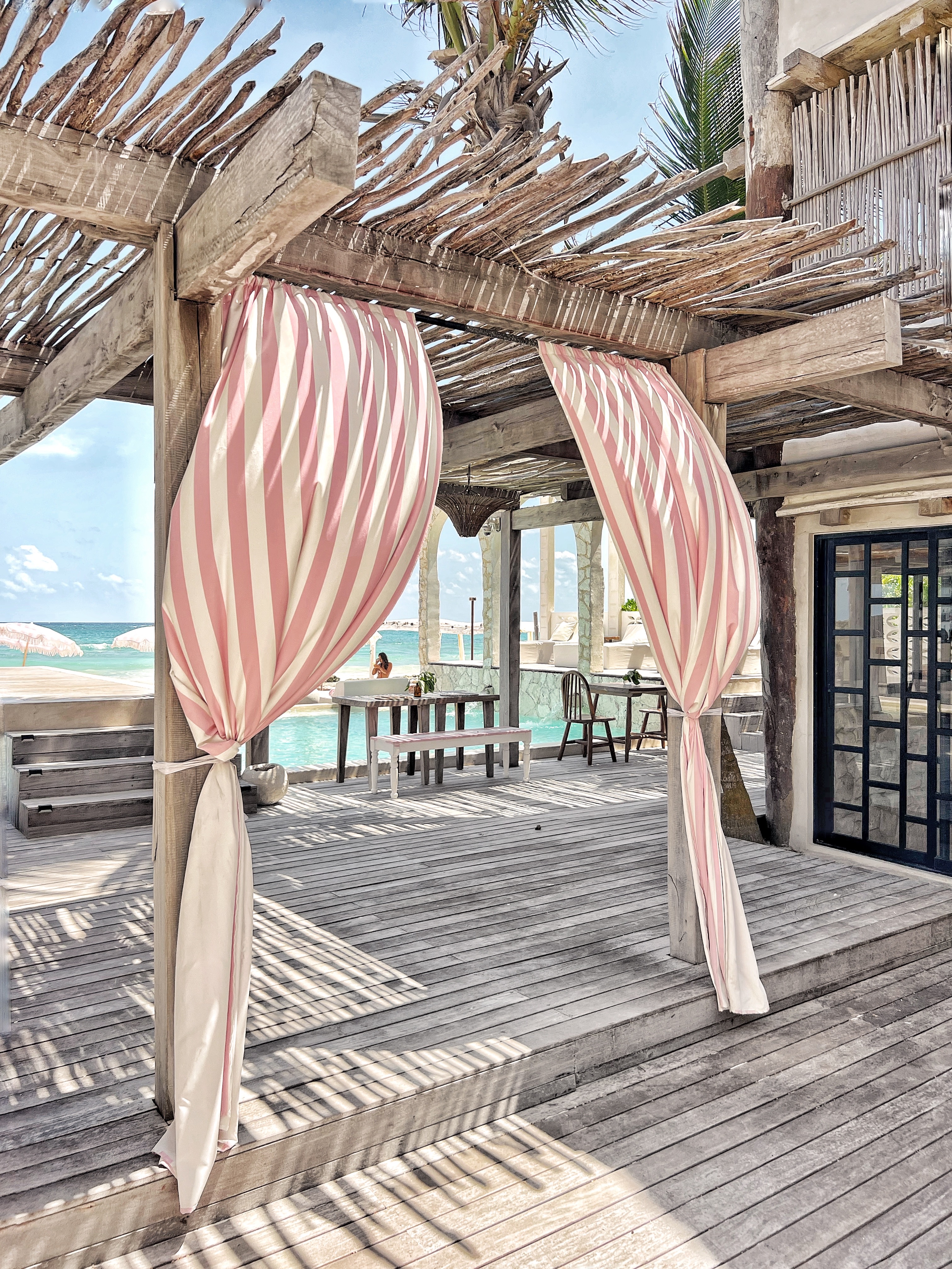 Pink striped curtains on deck with ocean view at Chi Ka Tulum